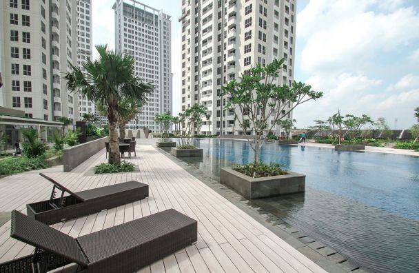 Swimming pool and wooden deck with loungers at M-Town Residence