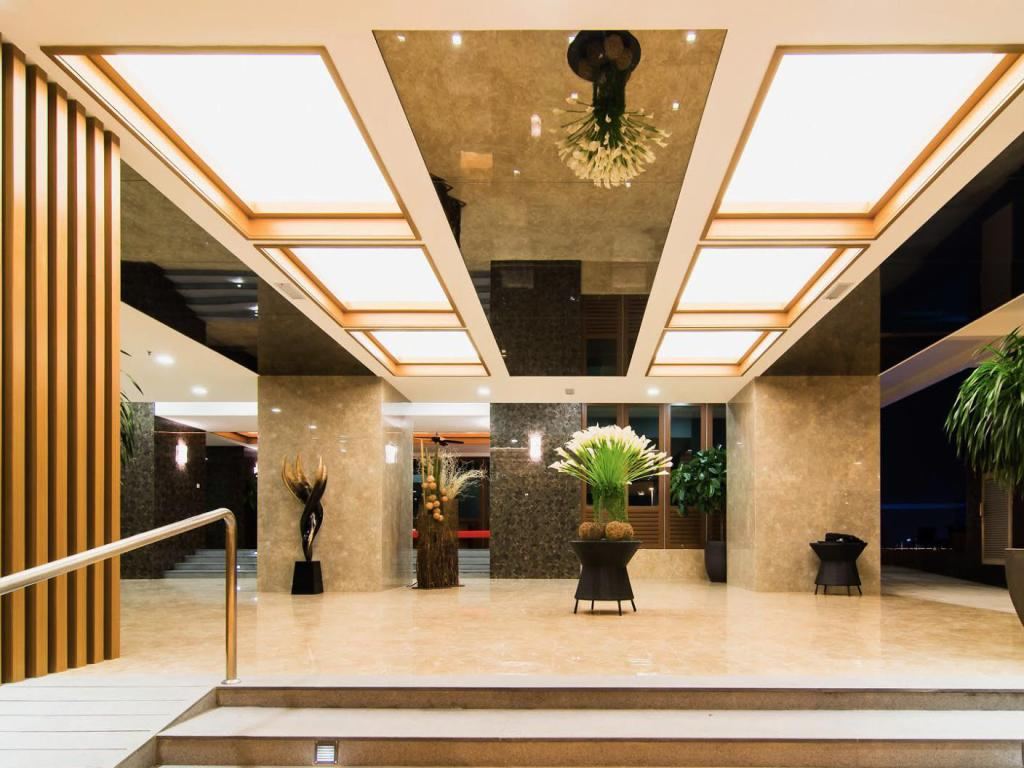 Marble lobby with lit ceiling panels and floral arrangements