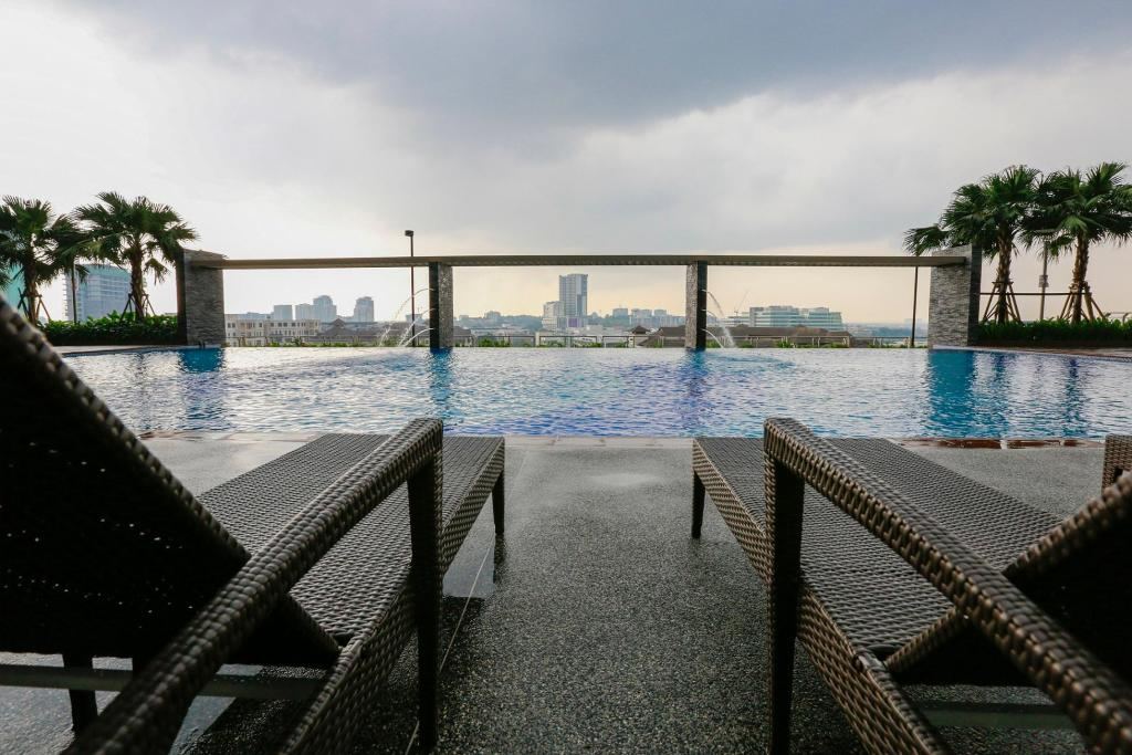 Infinity pool with loungers in the foreground and the Cyberjaya skyline beyond