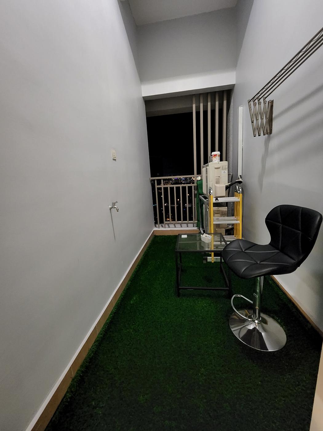 Balcony with artificial turf, a small table and a stool